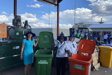 Grotheer mit Botschafterin und Bürgermeisterin neben bunten Abfalltonnen